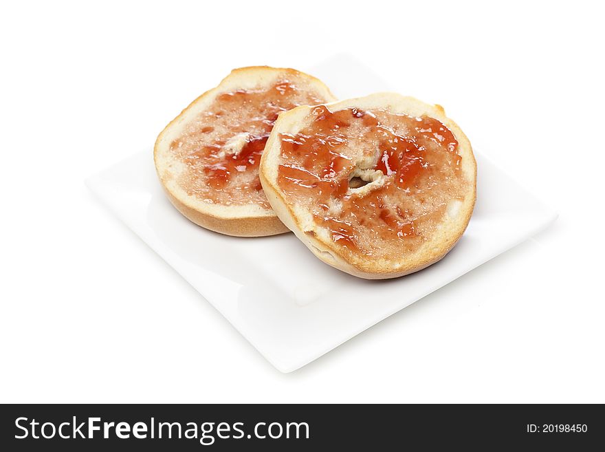 A plain bagel with strawberry jelly against a white background