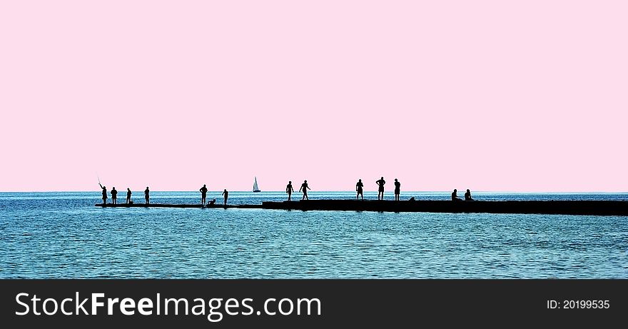 People silhouettes on a breakwater