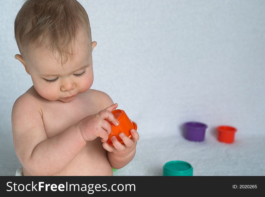 Image of adorable baby playing with stacking cups. Image of adorable baby playing with stacking cups