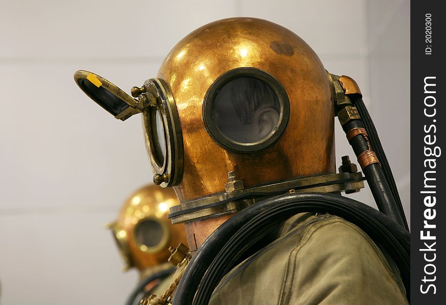 Two mannequin are dressed in diving suits with round copper helmets