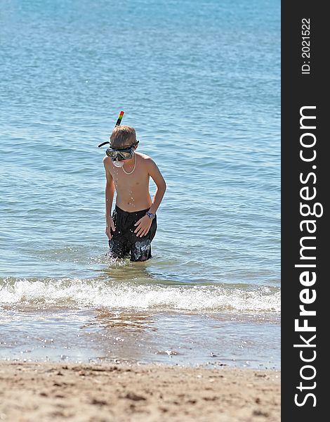 Boy with snorkel coming out the sea. Boy with snorkel coming out the sea