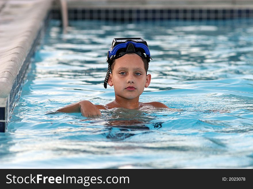 Boy swimming in pool with mask on