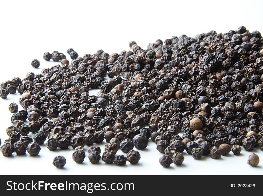 Whole black pepper on white. Whole black pepper on white