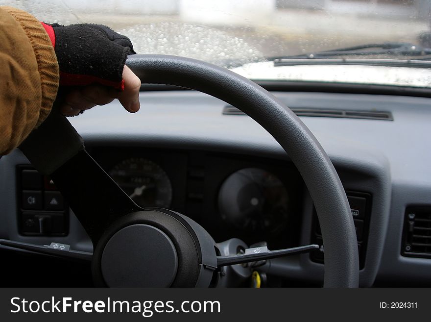 Hand in half-glove on the wheel of a car. Hand in half-glove on the wheel of a car