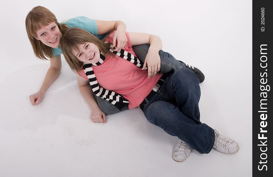 Two teen girls on the floor and they are very happy. Two teen girls on the floor and they are very happy