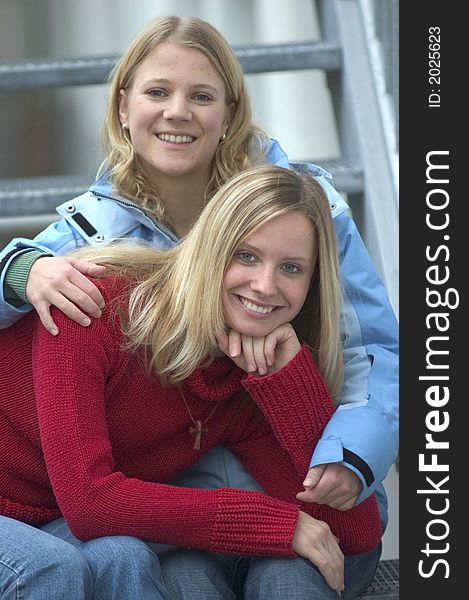 Two young blond women sitting on stairs. Two young blond women sitting on stairs
