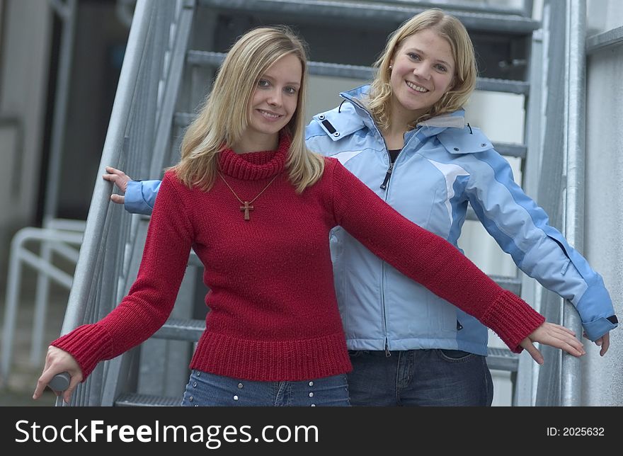 Two young blond women standing on stairs. Two young blond women standing on stairs