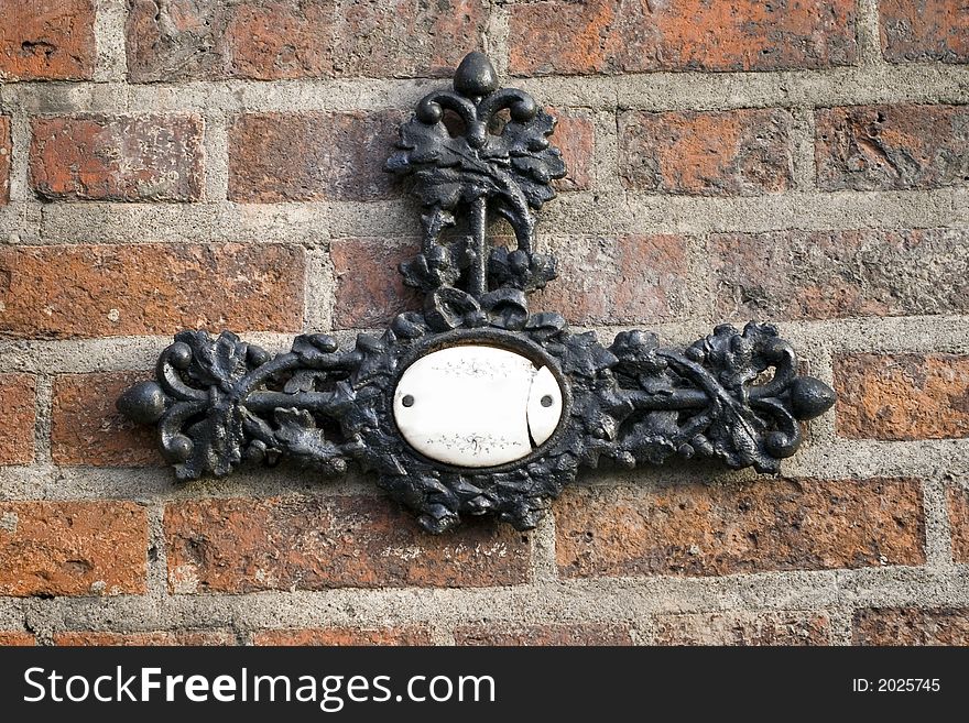 Metal cross on a brick wall