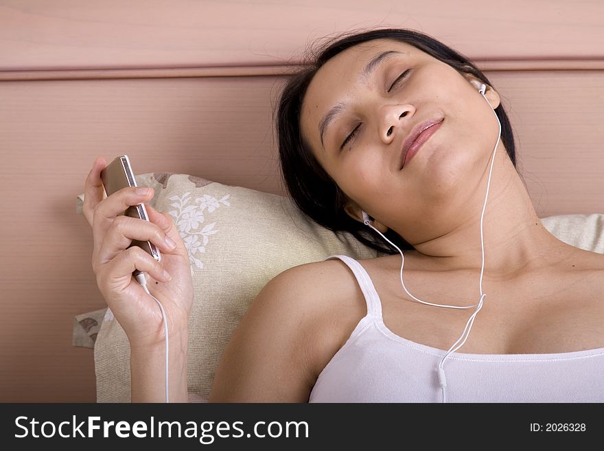 Pregnant woman listening to classical music on bed. Pregnant woman listening to classical music on bed