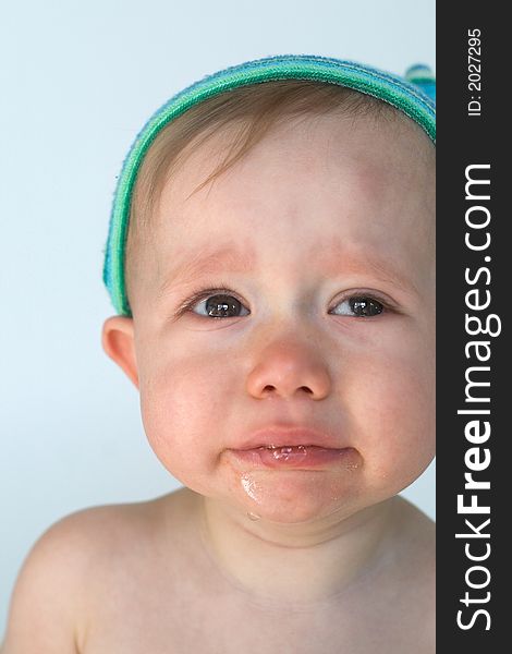 Image of crying baby sitting in front of a white background