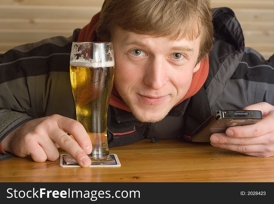 Man with beaker of beer and palm-size computer. Smiling. Man with beaker of beer and palm-size computer. Smiling