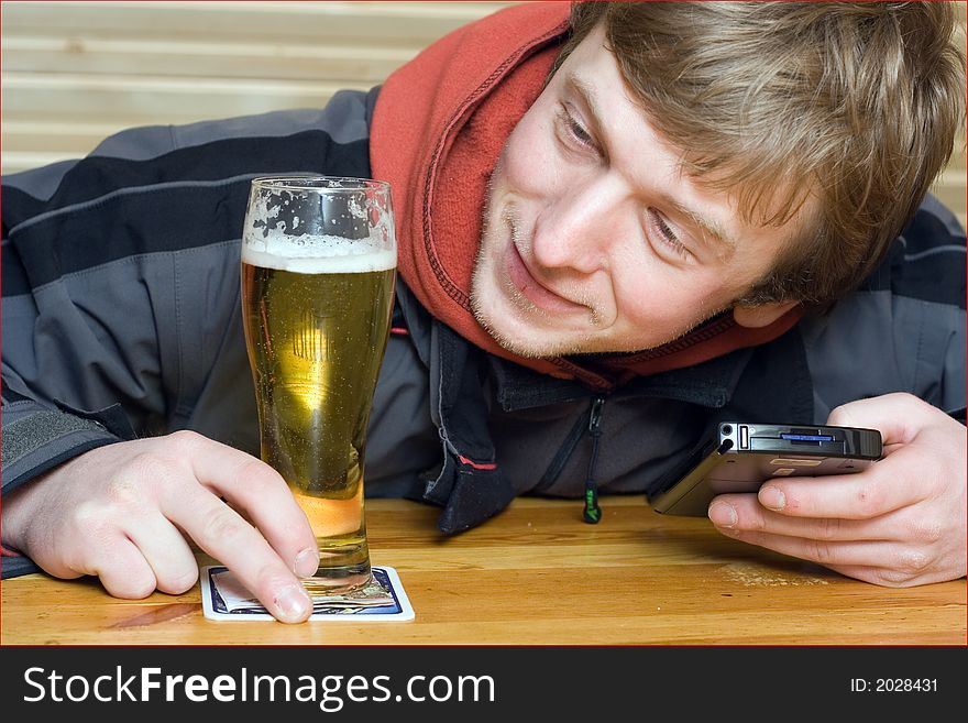 Man with beaker of beer and palm-size computer. Winking and smiling. Man with beaker of beer and palm-size computer. Winking and smiling
