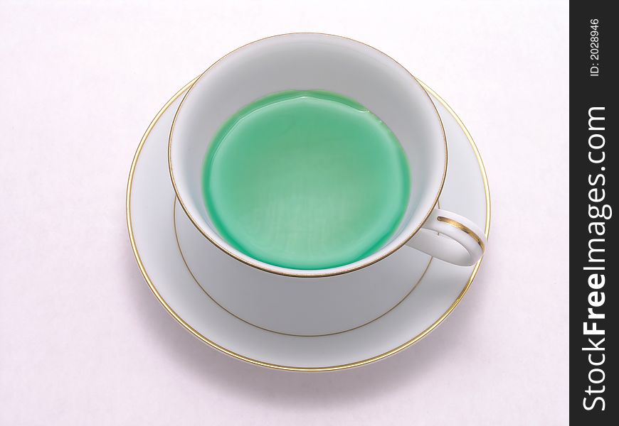 Green Herbal tea in a tea cup on saucer. Green Herbal tea in a tea cup on saucer