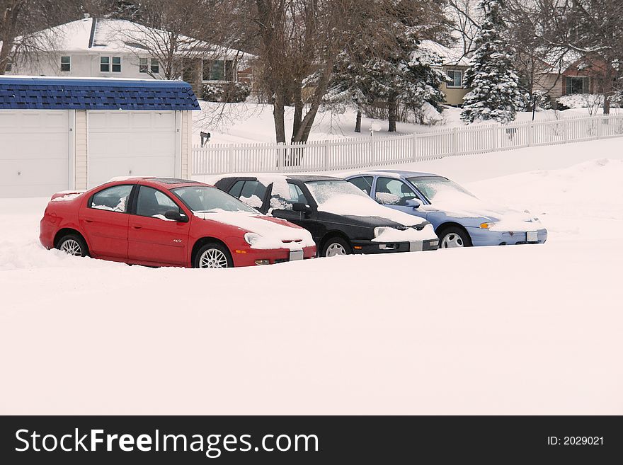A picture of three cars surrounded by snow after overnight snowfall. A picture of three cars surrounded by snow after overnight snowfall.
