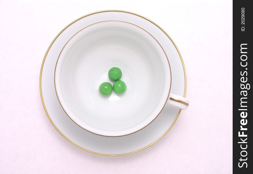 Three green candy balls in teacup