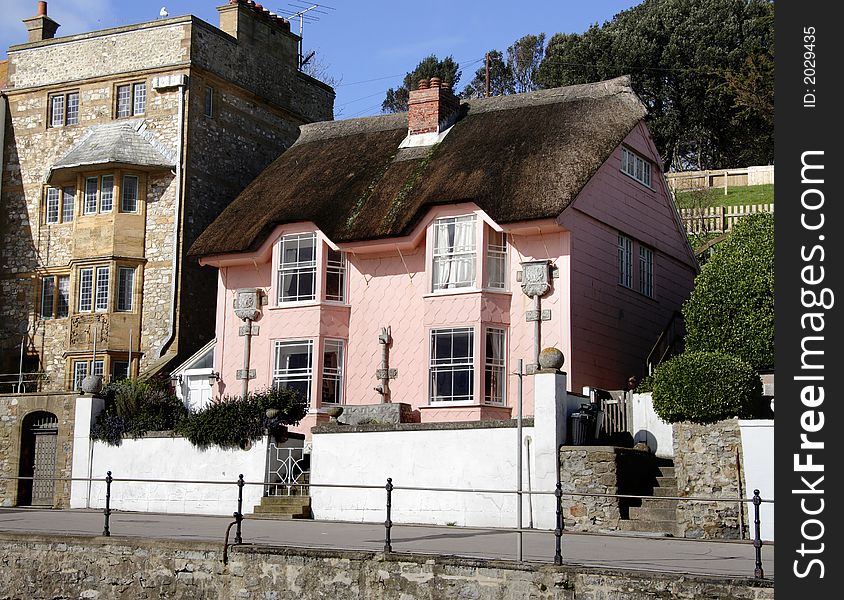 Pretty Pink Thatched Seaside House on the Promenade of an English Coastal resort. Pretty Pink Thatched Seaside House on the Promenade of an English Coastal resort