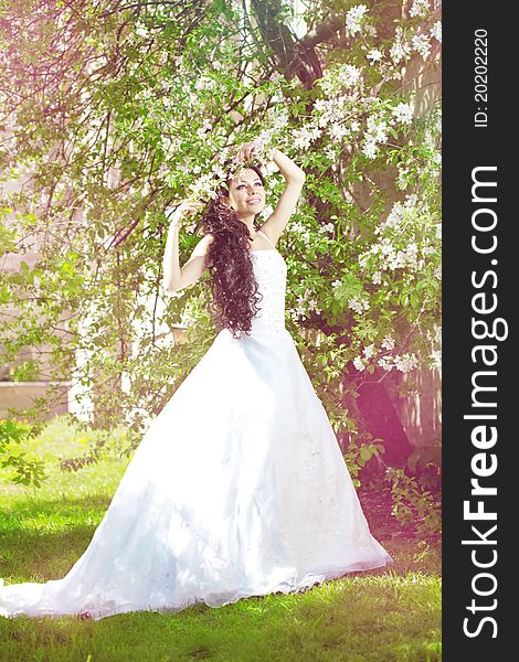The image of a beautiful bride in a blossoming garden