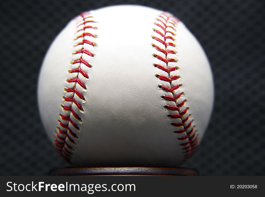 Up close shot of a baseball against a dark background.