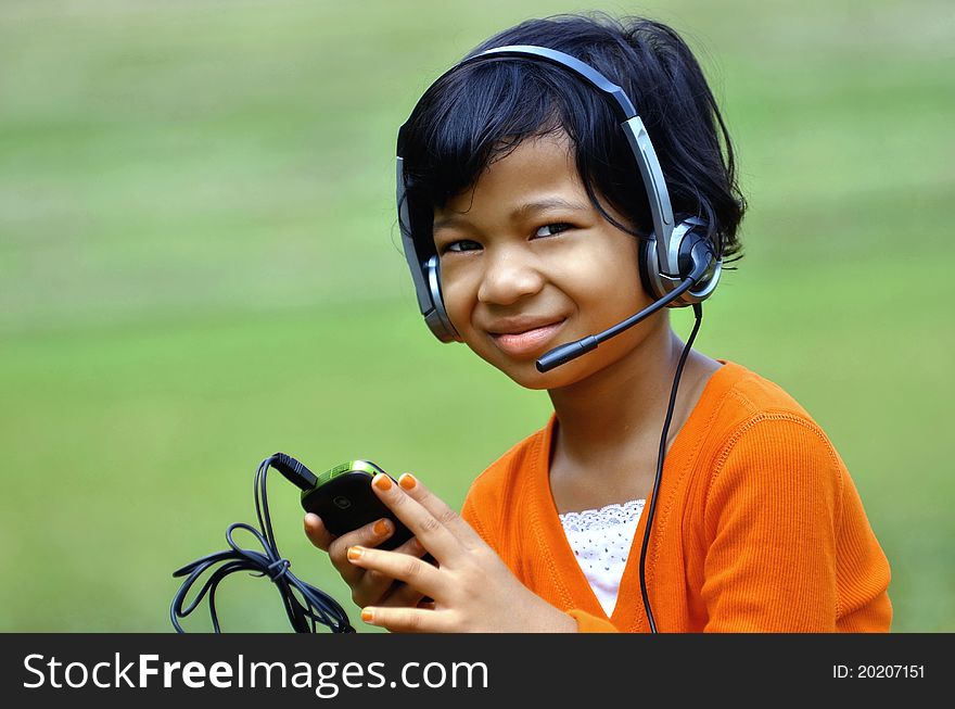 Cute asian girl using a headset and a microphone. Cute asian girl using a headset and a microphone