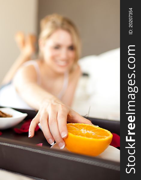 Young woman picking an orange for breakfast