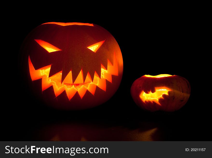 Jack-o'-lanterns, spooky Halloween pumpkins glowing in the night.
