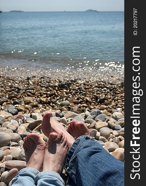 Two pairs of feet on the sea coast. Two pairs of feet on the sea coast