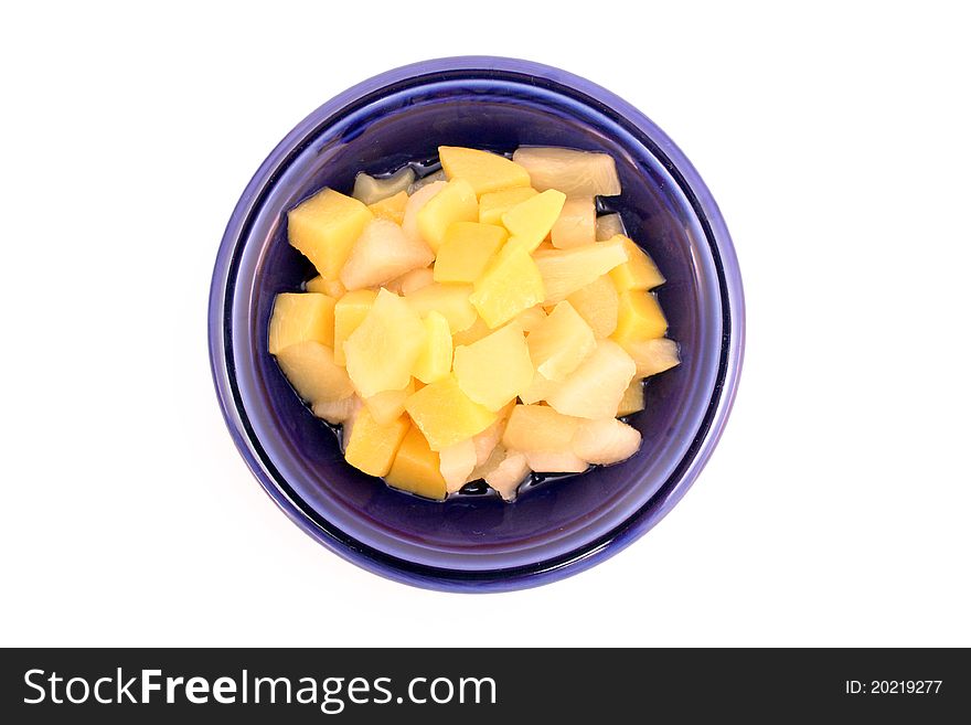 Fruit cocktail in blue bowl isolated over white background