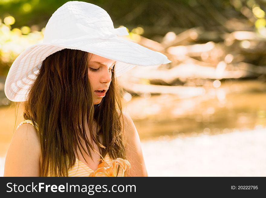 Picture of a beautiful young lady wearing a white bonnet stream side. Picture of a beautiful young lady wearing a white bonnet stream side