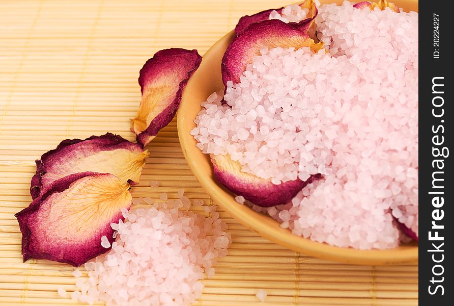 Bowl with sea salt and dry rose petals. Bowl with sea salt and dry rose petals