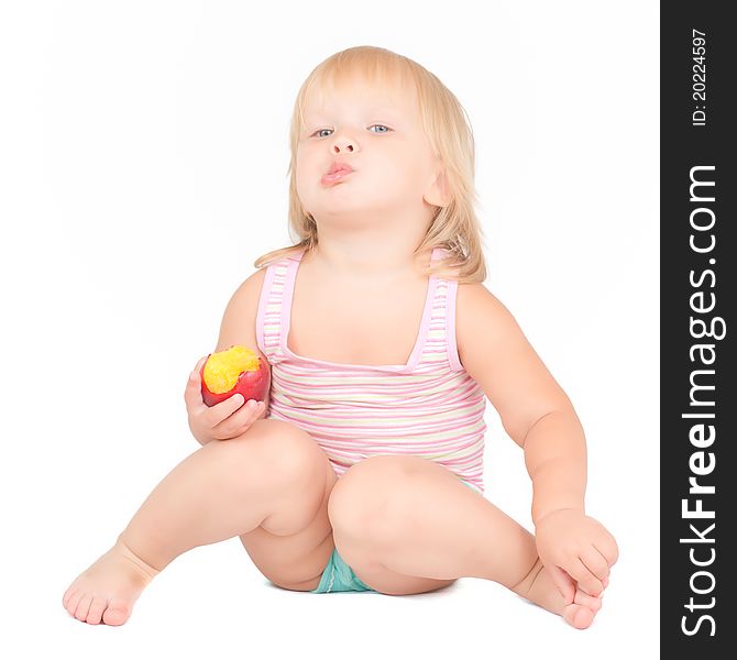 Adorable toddler girl eat red fresh peach sitting on white