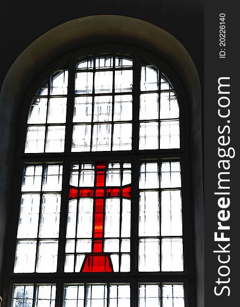 Red cross at a window with a lattice and bright light