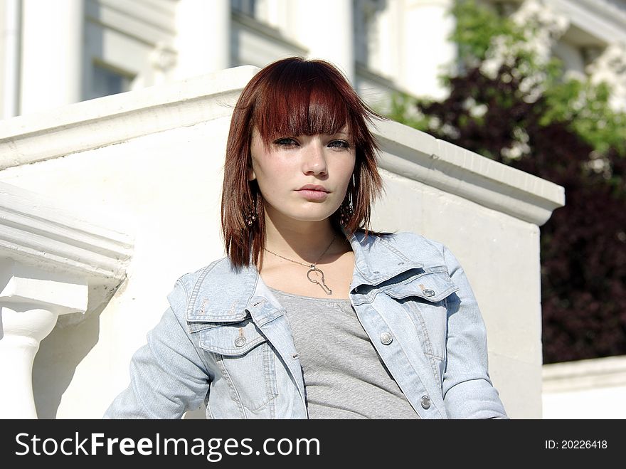 Teen girl in jacket before building with columns. Teen girl in jacket before building with columns