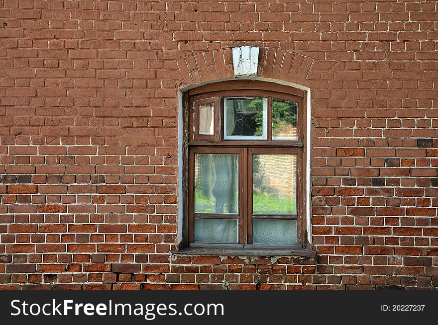 Window in brick wall. The window on the background of the old red brick wall. Window arch in the Art Nouveau style. Vintage window.