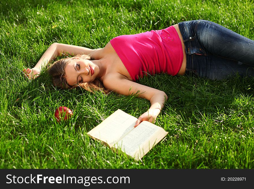 Woman reading book in the park on the grass. Woman reading book in the park on the grass