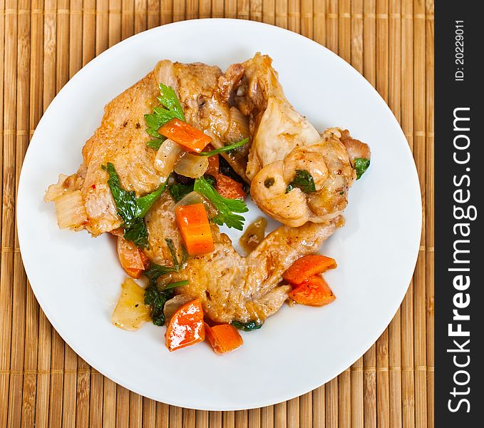 Fried chicken wings with vegetables decorated with parsley