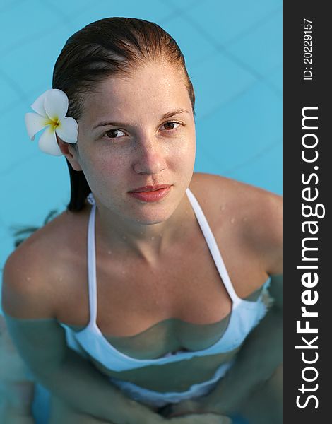 Young woman in swimming pool with flower in hairs. Young woman in swimming pool with flower in hairs