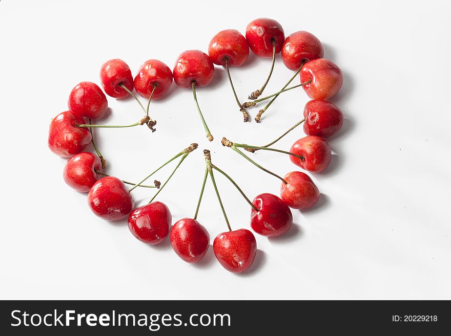 Sweet cherries in the shape of heart isolated on white background. Sweet cherries in the shape of heart isolated on white background