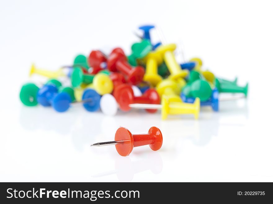 A colorful thumb tack against a white background