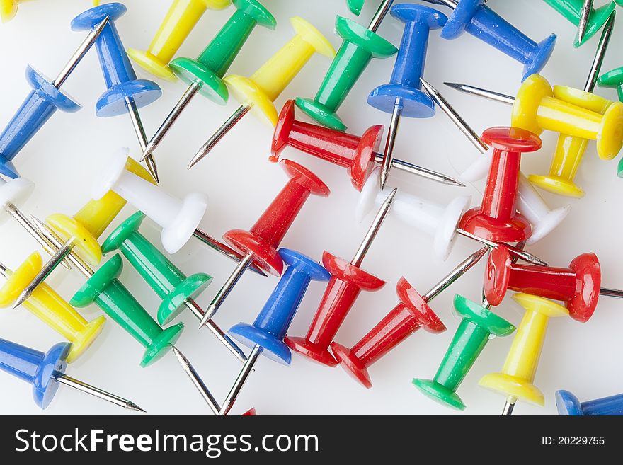 A colorful thumb tack against a white background