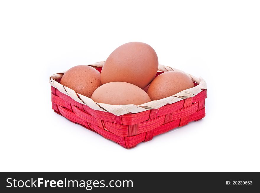 Eggs in a wicker red basket on white background