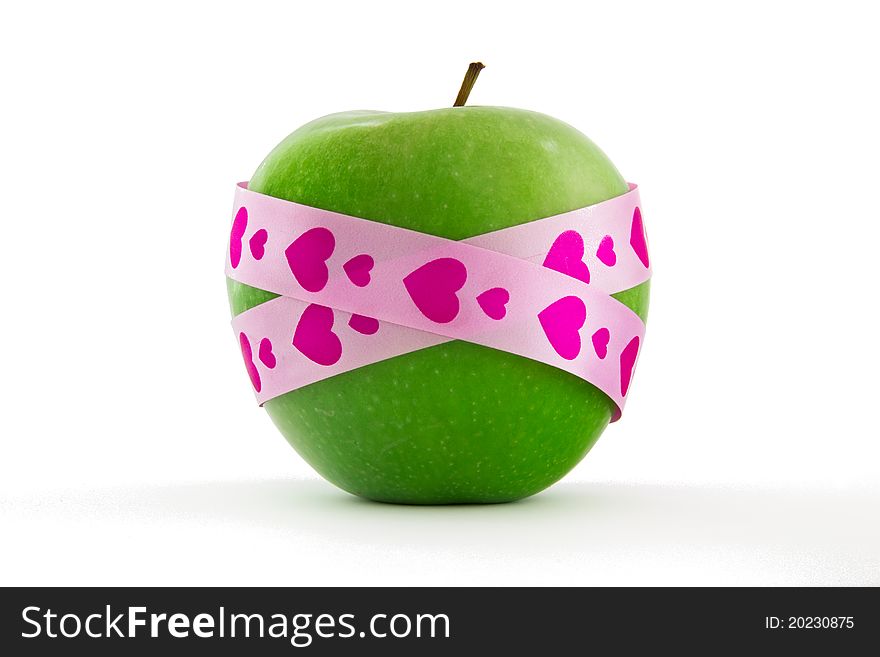 Green apple with pink heart pattern gift ribbon, isolated on white. Green apple with pink heart pattern gift ribbon, isolated on white.