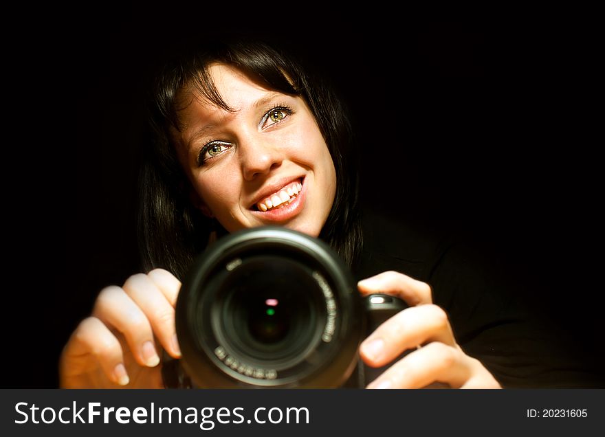 Beautiful girl with camera, black background