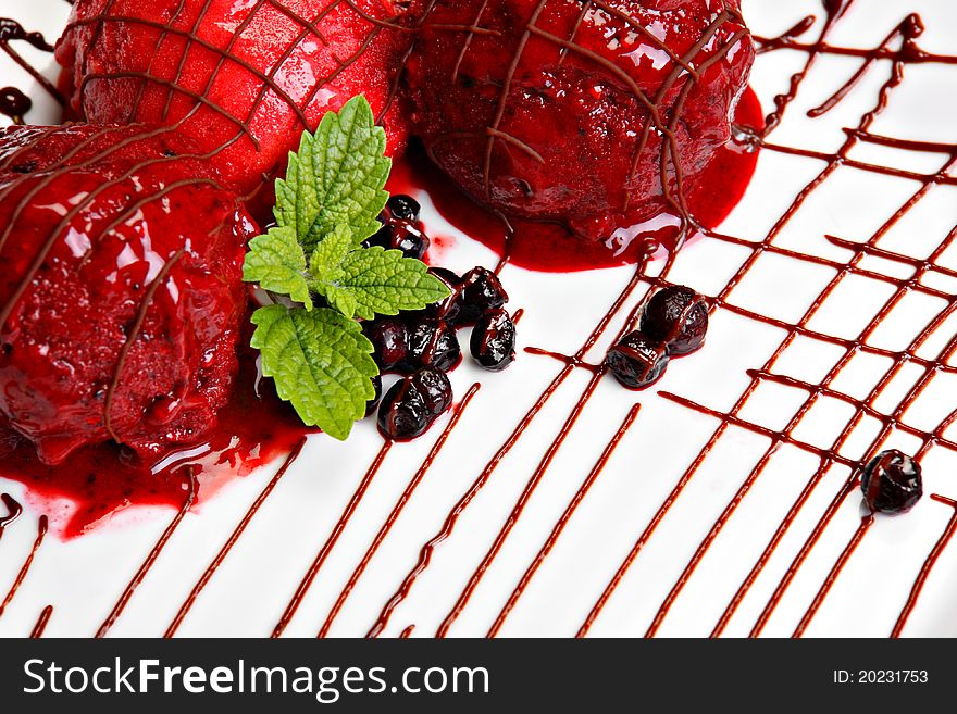 Berry fruit ice cream served on the white plate. Decorated with mint.