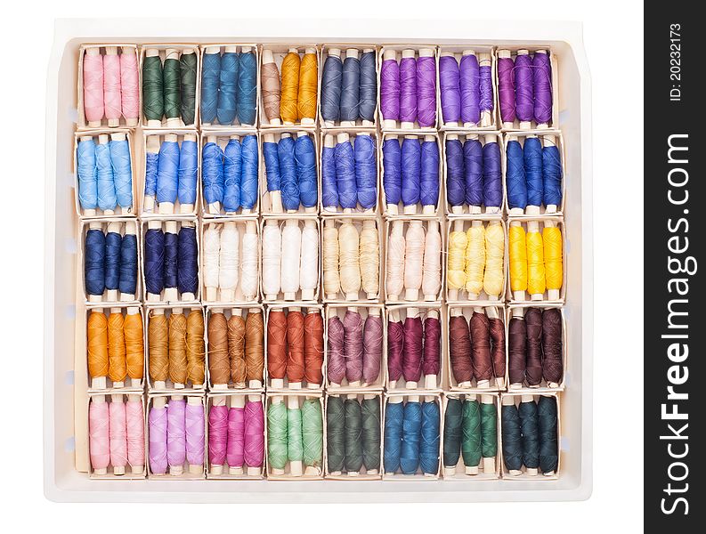 Sewing kit with colored spools of threads isolated