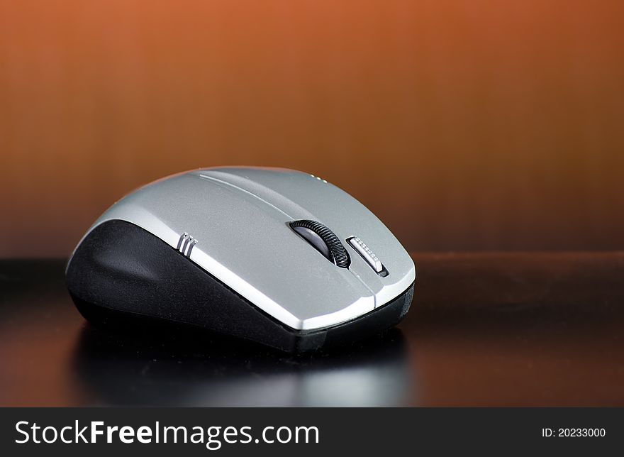 Wireless mouse on brown background