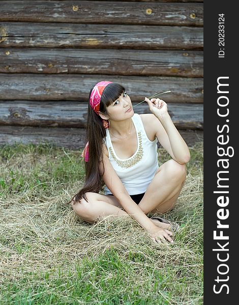 Beautiful girl sitting on hay in country