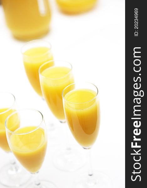 Many glasses of fresh orange juice in a row with copy space