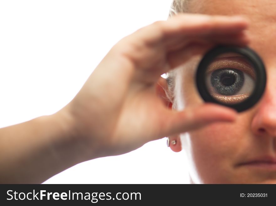 Female face with magnified blue eye whilst looking through magnifying lens. Female face with magnified blue eye whilst looking through magnifying lens