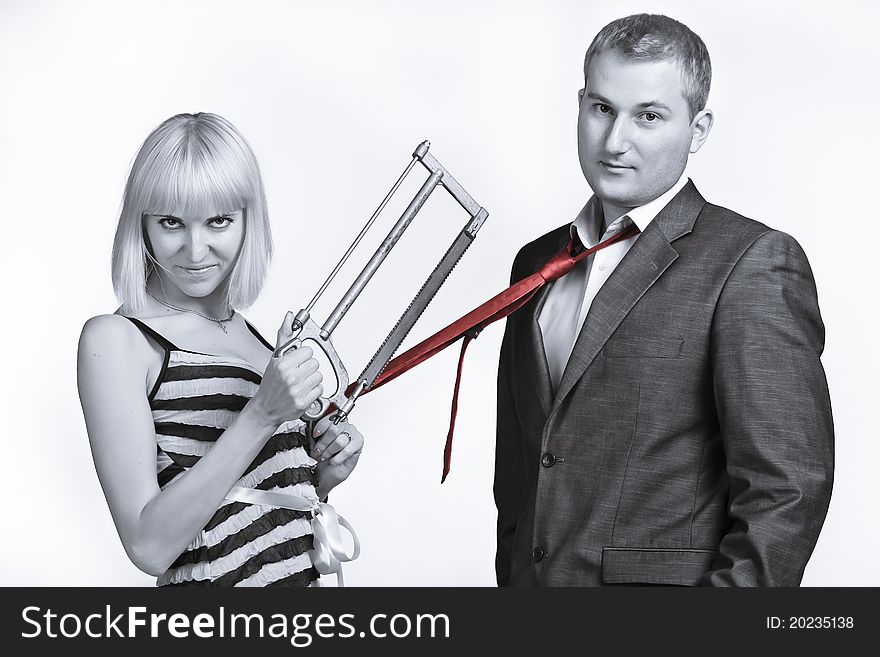 Beautiful young couple fool around with a saw. Beautiful young couple fool around with a saw