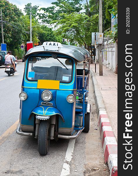 Thai tuk tuks sit parked awaiting tourists